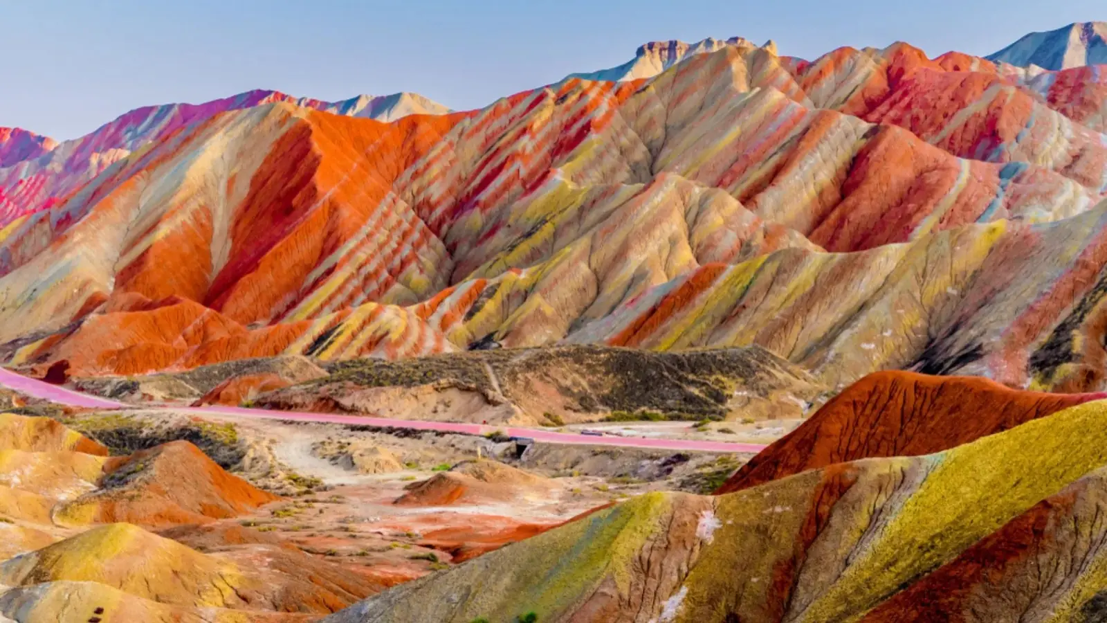 A road curving through the rainbow-striped Danxia hills at Zhangye in Gansu